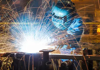worker with protective mask welding metal